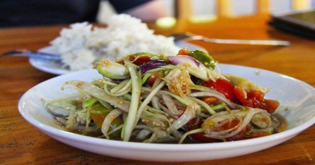 Preparing tam mak hoong, Laos's spicy green papaya salad